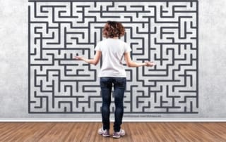 Foto van een denkende jongen die een doolhof ziet