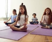 mediterende kinderen in groep op yogamatje