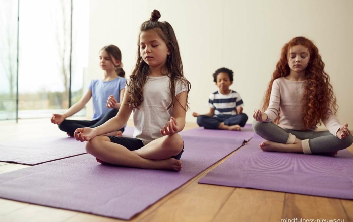 mediterende kinderen in groep op yogamatje
